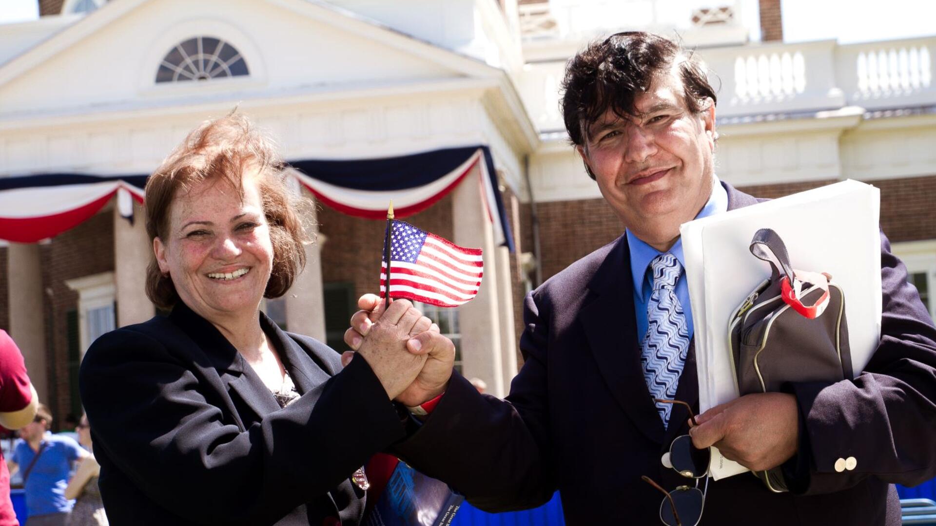 A refugee couple hold a U.S. flag at their naturalization ceremony in Charlottesville, VA
