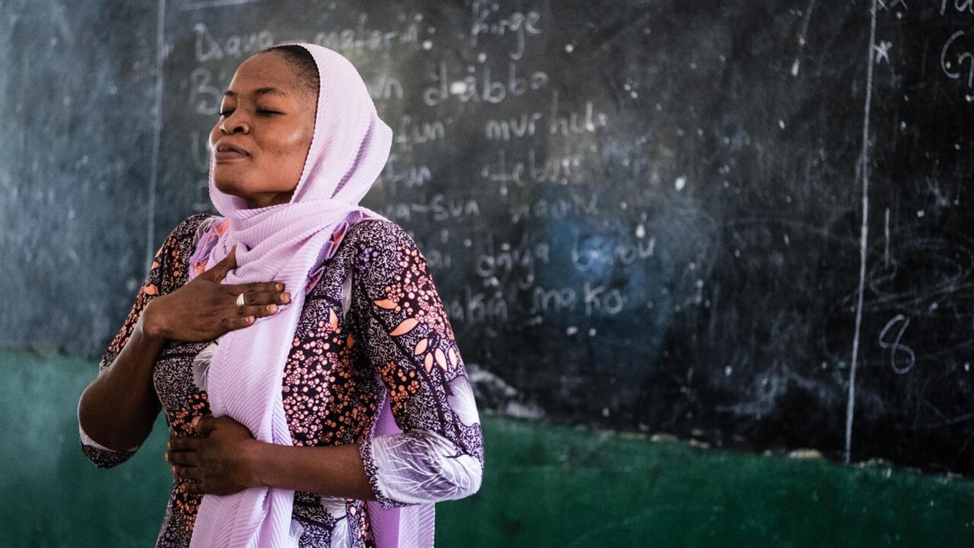 A teacher in Nigeria demonstrates mindfulness breathing techniques to students
