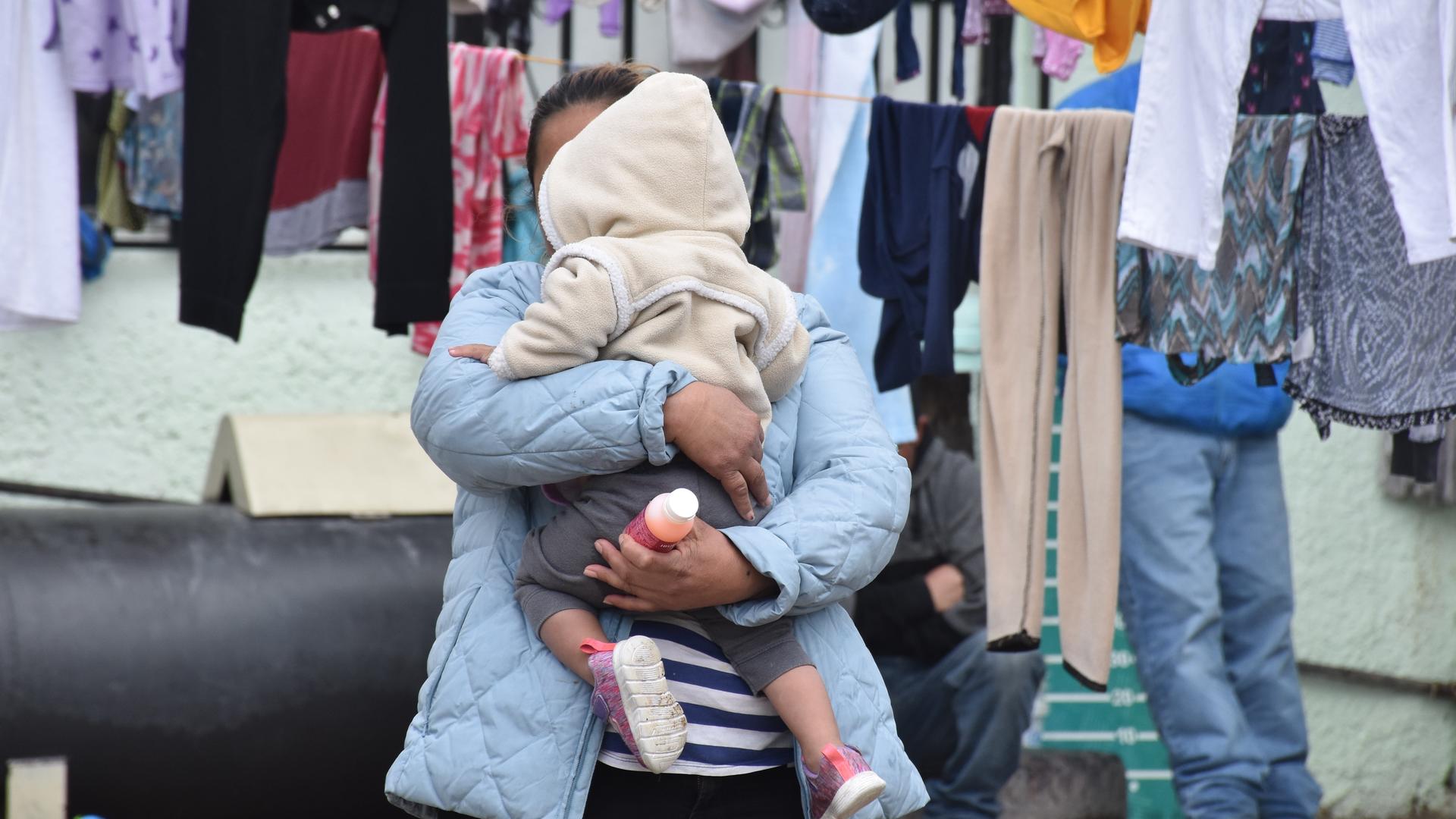 Alma, an asylum seeker from Guatemala, and her daughter wait for their laundry to dry in the outdoor living space of a shelter in Ciudad Juarez. Alma, an asylum seeker from Guatemala, and her daughter wait for their laundry to dry in the outdoor living space of a shelter in Ciudad Juarez.