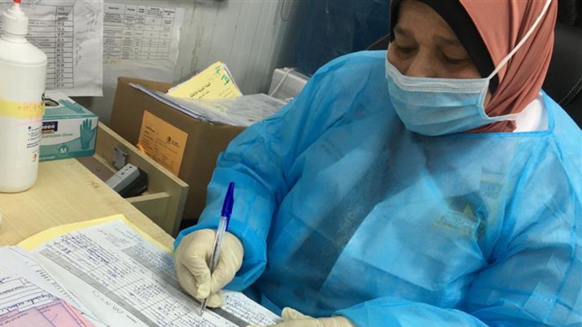 IRC’s frontline workers in Jordan continue to provide essential health services in refugee camps in Jordan. An IRC staff member in Jordan looks over paperwork.