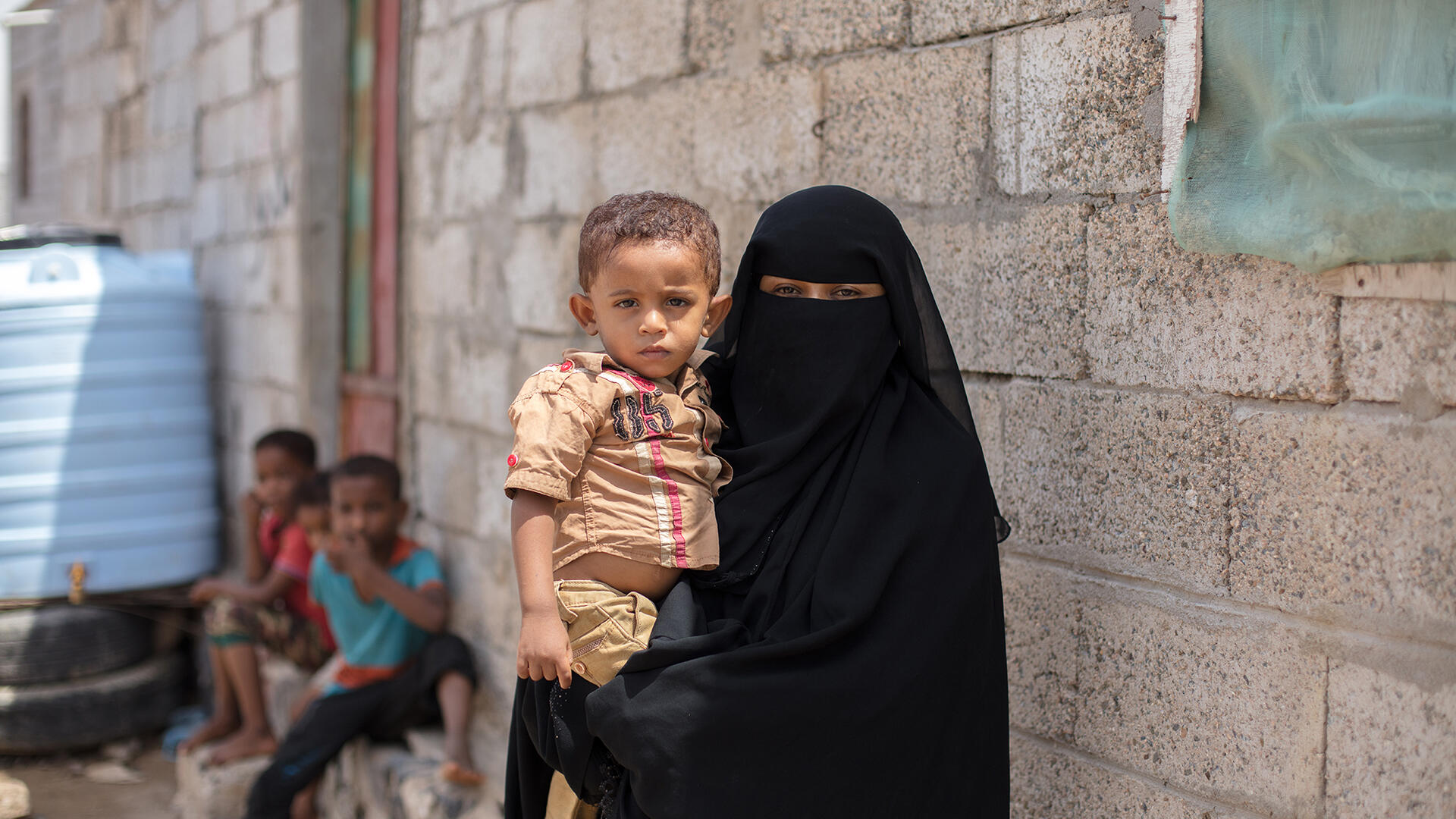 A mother recieves treatment for her malnourished children from the IRC. Learn how to help Yemen. A Yemeni mother holds her young son.