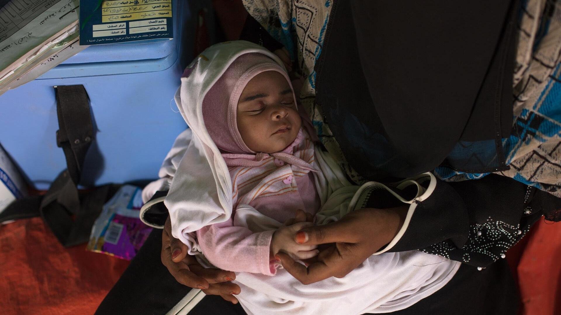 Baby Enqath, or "Rescue," sleeps in her mother's arms