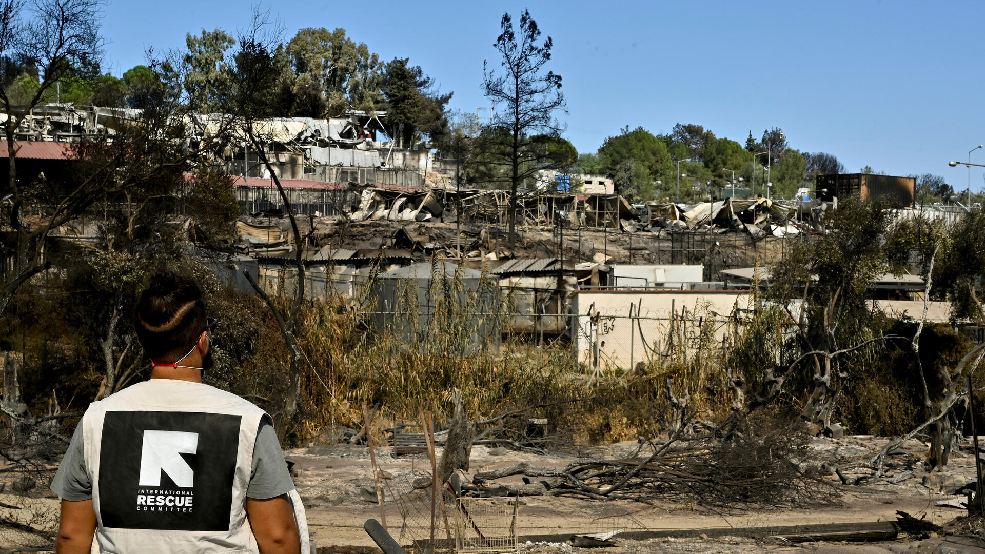 An IRC staff member views the burnt-out Moria refrugee camp in Lesbos, Greece
