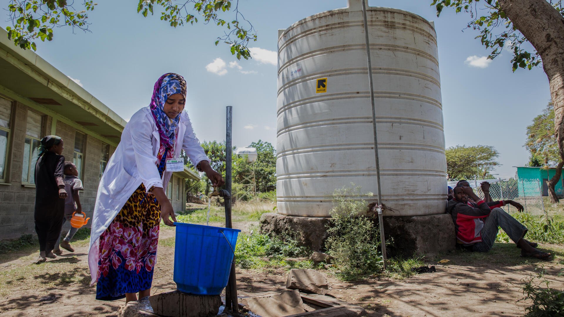 An IRC staff member fills a bucket at a water point in Ethiopia