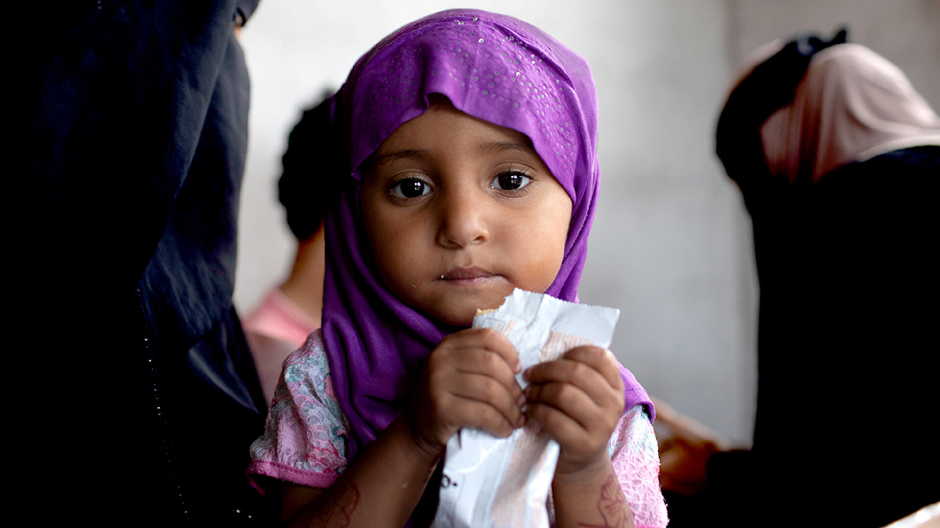 A young girl in Yemen being treated for acute malnutrition eats a peanut butter based nutritional paste. 