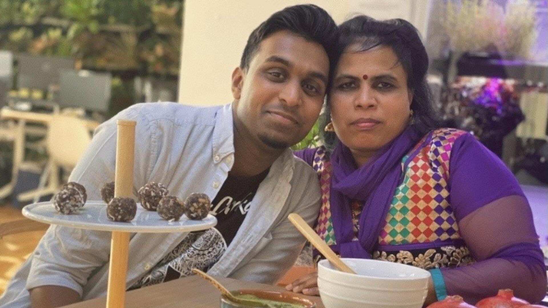 Chef Shanthini Sivakumar and her son Sarujen, both employees at Eat Offbeat Sitting at a table with an array of food in front of them, Shanthini and Sarujen lean toward one another and look at the camera.