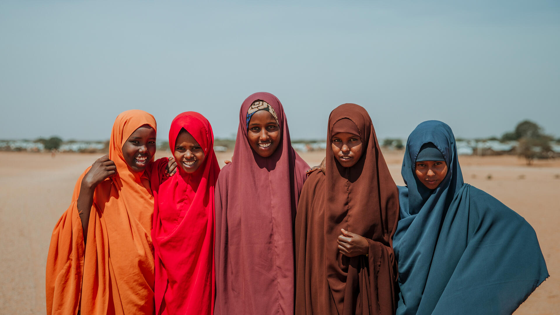 From the left, Ampiya Mustafa, Asha Shoaib Hassan, Hibo Saeed, Shamsa Mohammed and Nurta Issa have become friends after joining the IRC's Girl Shine program in Ethiopia. Five girls who are part of the IRC's Girl Shine program -- Ampia, Asha, Hibo, Shamsa, and Nurta -- stand together for a photo in a dry landscape in Ethiopia.